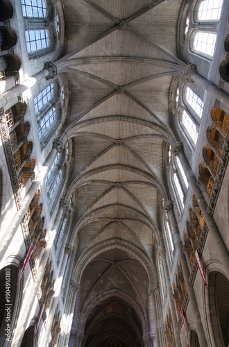 Bild auf Leinwand Soaring Gothic Cathedral Rib Vault - Dramatic upward view of a historic Gothic cathedral's intricate rib vaulted ceiling and clerestory windows, highlighted by bright sunlight