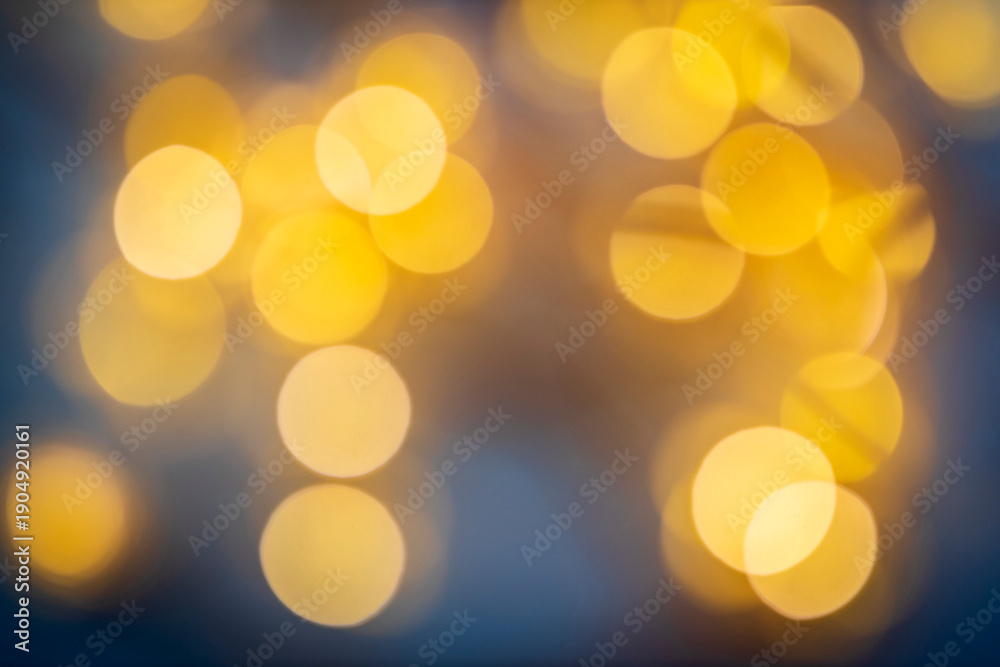 Fototapeta premium Soft golden bokeh lights background with warm blurred circles, festive atmosphere.