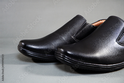 Foto Close-up shot showcasing a pair of classic black faux leather slip-on dress shoe