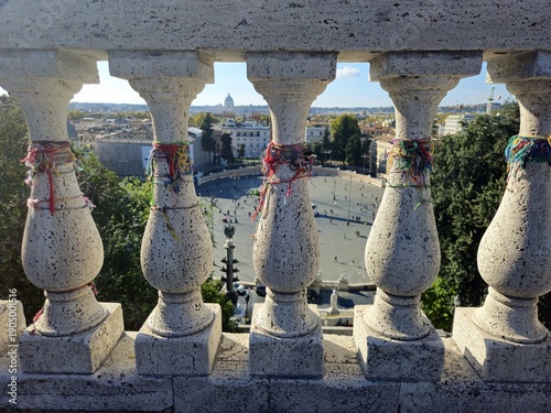 Lucky bracelets attached to the balustrade of a terrace overlooking one of the squares of the city of Rome.
