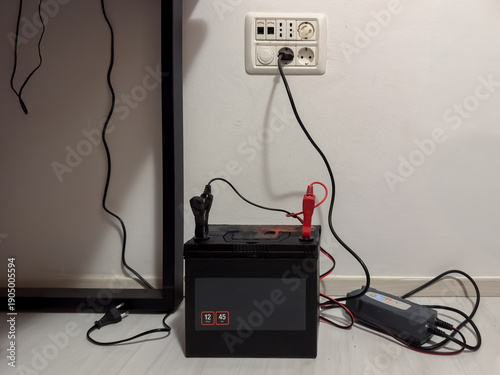 Obraz na plátne Car Battery,Aaccumulator is Charging with Smart Charger at home