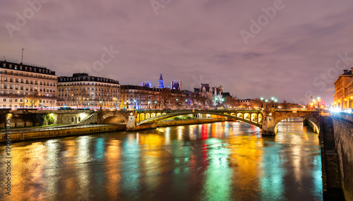 Fotografija Pont Notre-Dame bridge crosses the Seine river with colorful city light reflecti