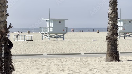 Lifeguard towers framed by palm trees on Santa Monica Beach
