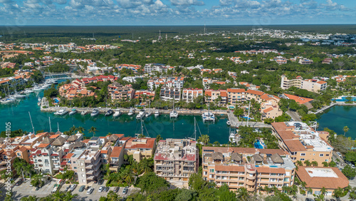 Vista aérea panorámica de marina con yates y desarrollo hotel frente al mar Caribe en destino tropical. Escena que representa turismo de lujo, inversión inmobiliaria y estilo de vida exclusivo e
