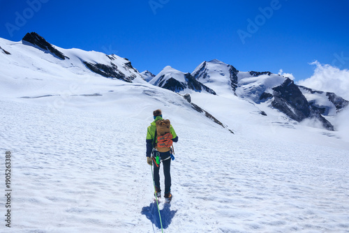 Bilde på lerret Mountaineer in rope team with crampons and mountain glacier panorama with summit