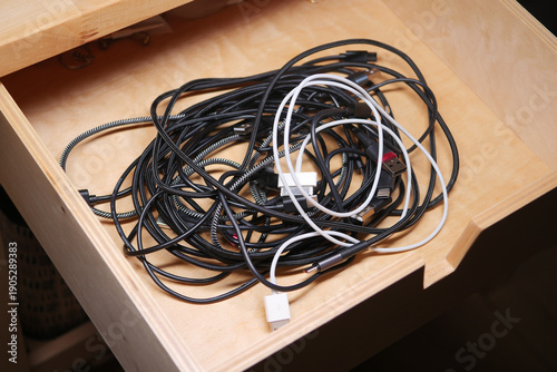 Obraz na plátne Messy drawer filled with various charging cables and wires