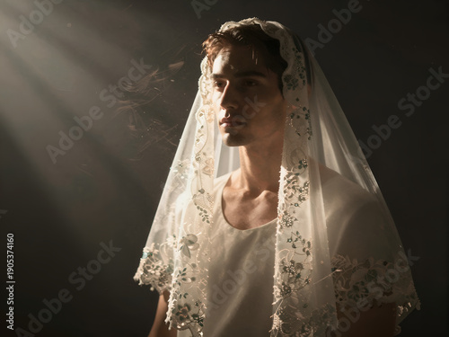 Intense volumetric lighting on man wearing bridal veil with calm face