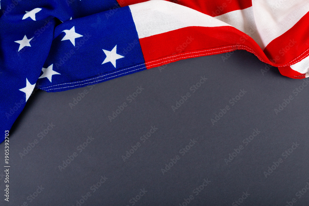 Obraz premium High angle view of america flag with stars and stripes pattern on black table with copy space