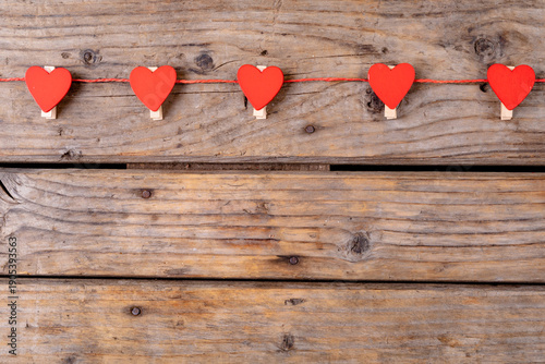 Overhead shot of red heart shaped decoration with copy space on wooden table