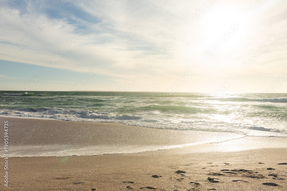 Obraz premium Scenic view of waves on shore at beach against sky during sunny day