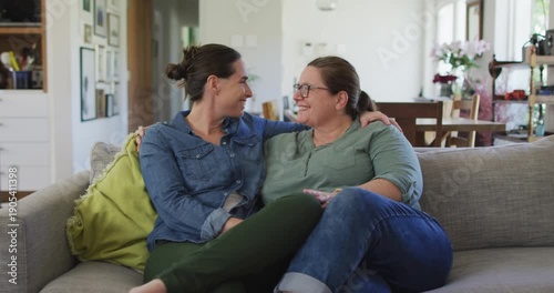Portrait of caucasian lesbian couple looking at camera, embracing