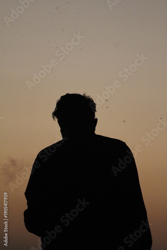 A person's silhouette against a twilight sky
