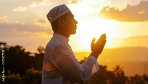 A devoted man in prayer during the beautiful sunset, hands raised in supplication, embodying spiritual connection and profound faith in a tranquil outdoor setting