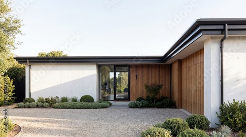 Modern single-story house with minimalist design featuring white walls and wooden accents surrounded by lush greenery