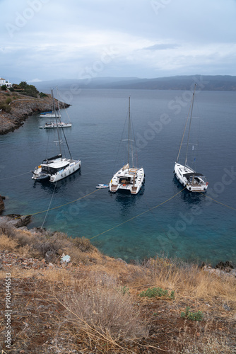 Hydra Island harbor on a cloudy day with yachts moored along the waterfront in the Saronic Gulf, Greece.