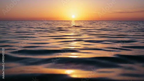 Sunset reflection over calm ocean waters with soft waves  