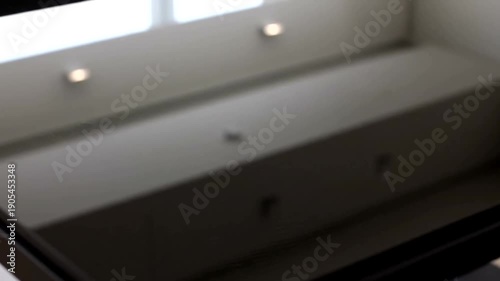 Empty dark room with ceiling lights and reflections.