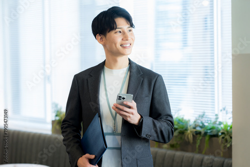 オフィスでスマホを使うビジネスマン