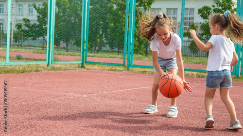 summer vacation, sport, games and friendship concept - happy children playing basketball outdoors