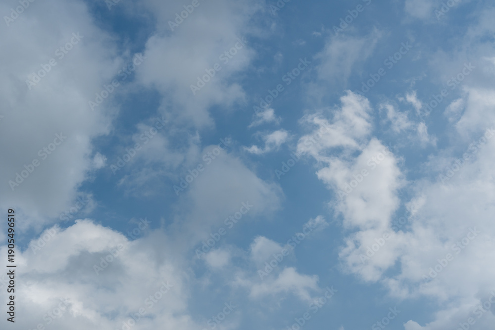Obraz premium Scattered White Clouds Against Bright Blue Sky Background