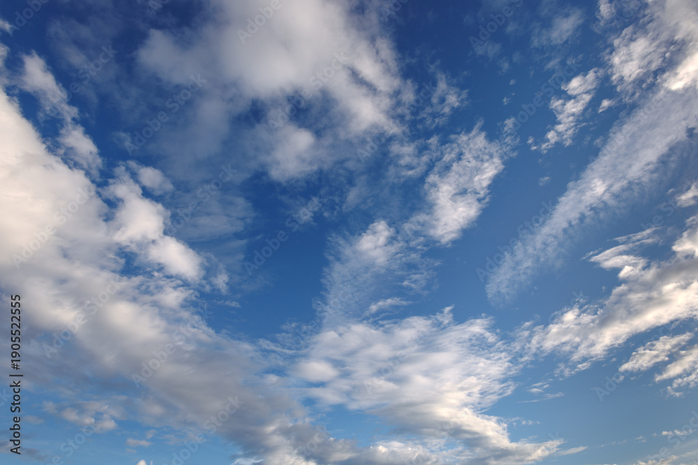 Fototapeta premium Beautiful evening sky between 4 and 5 PM with fluffy white clouds and soft daylight. Serene and clear atmosphere, perfect for natural background, heaven concept, or weather-related design. 