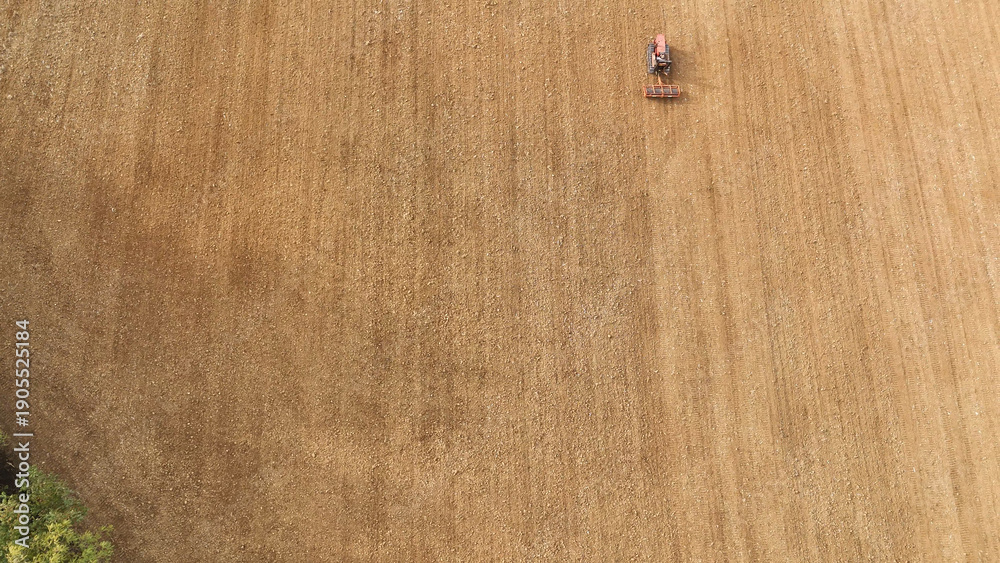Fototapeta premium Vintage crawler tractor cultivating agricultural land in rural Tuscany, Italy, an aerial top down view of farming preparing soil for sowing crops