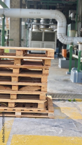 Wooden pallets are stacked in layers, ready for use before being moved.