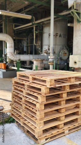 Wooden pallets are stacked in layers, ready for use before being moved.