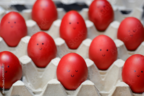 фотографія Red Easter eggs with drawn smiling faces on carton