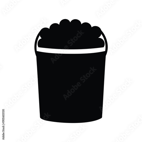 Black and white silhouette of a bucket filled with rounded objects
