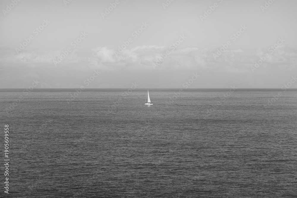 Fototapeta premium Ship sailing on the Atlantic Ocean on a sunny day seen from the island of Tenerife, Spain in black and white