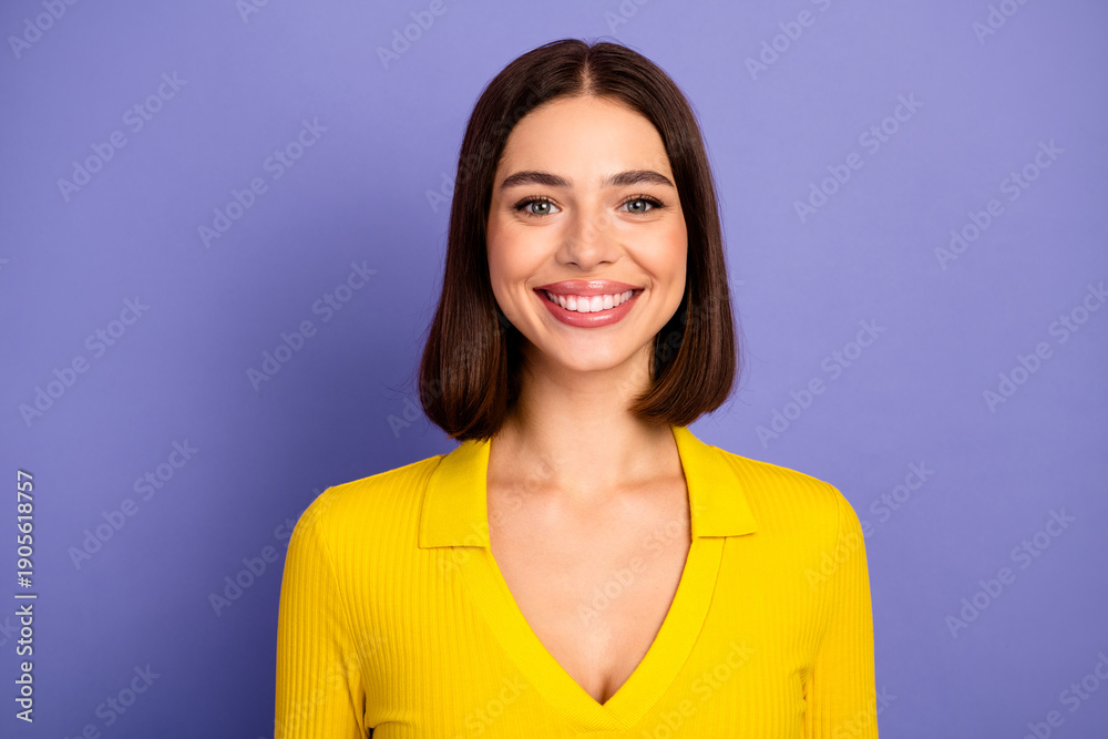Fototapeta premium Happy brunette woman in bright yellow blouse smiling against purple background lifestyle fashion stock photo