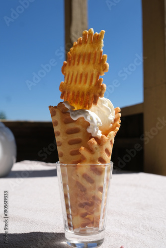 Homemade ice cream in a waffle cone on a rustic table in the summer countryside