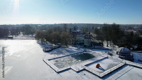 Zima w Zebrzydowicach na Śląsku w Polsce z lotu ptaka. Park z pałacem i zamarzniętym stawem.