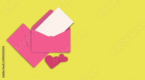 Pink envelopes with blank card and paper hearts on yellow background