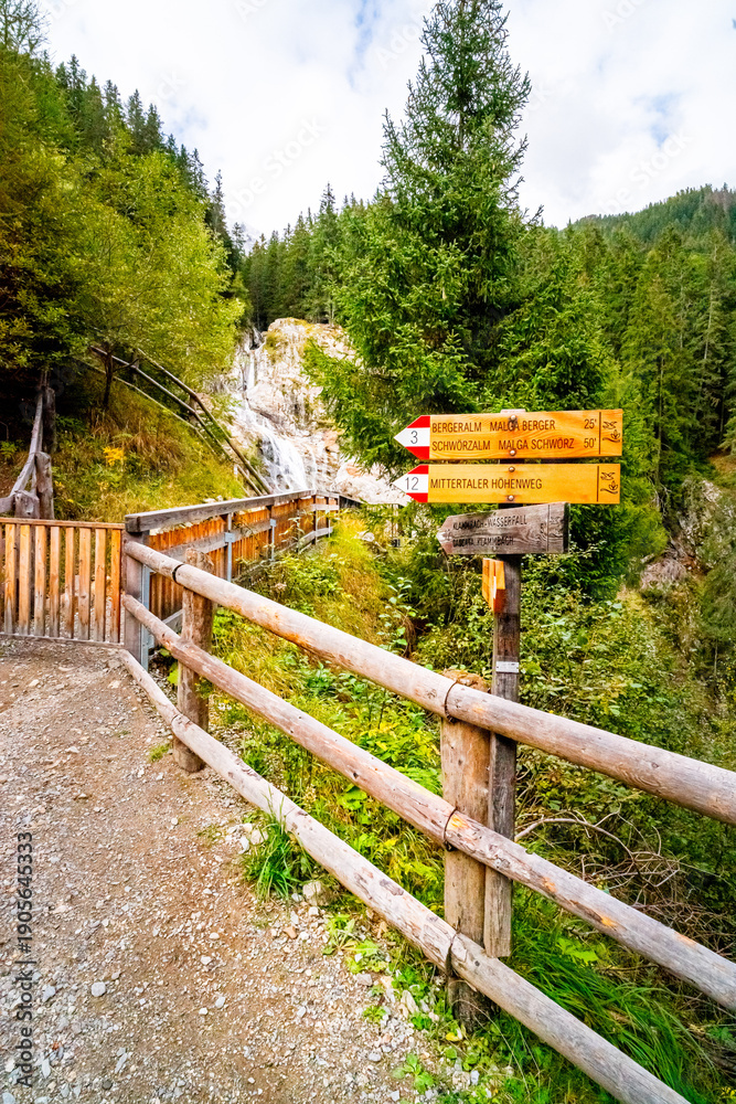 Fototapeta premium Hiking Trail to the Klammbach Waterfalls in the Antholz Valley South Tyrol in autumn 2025