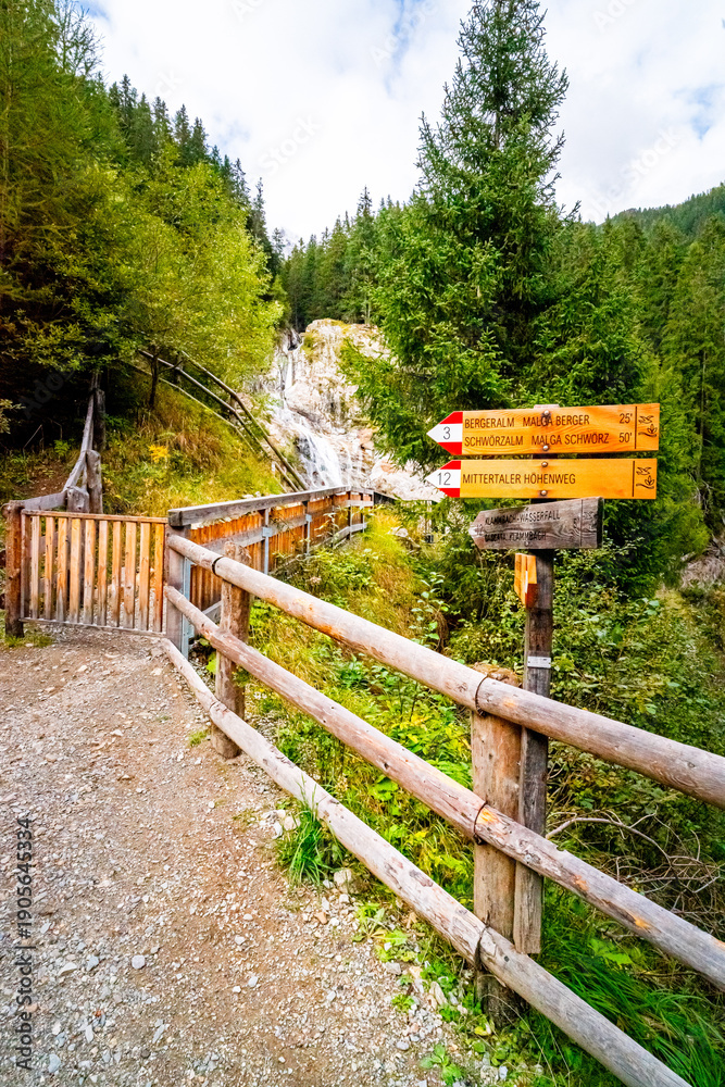 Fototapeta premium Hiking Trail to the Klammbach Waterfalls in the Antholz Valley South Tyrol in autumn 2025