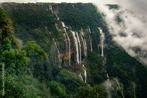 Seven sisters waterfall in sohra cherrapunji meghalaya cascading down canyon cliff covered in monsoon greens and clouds drifting. Popular tourist attraction.