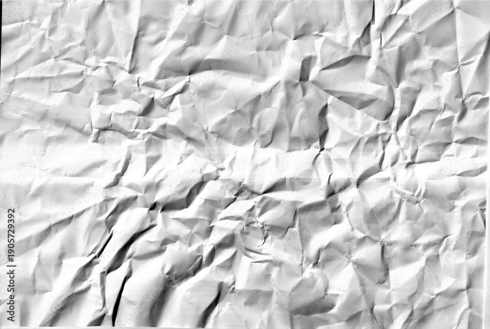 Obraz premium Crumpled white paper sheet texture with dark shadows and folds forming abstract pattern