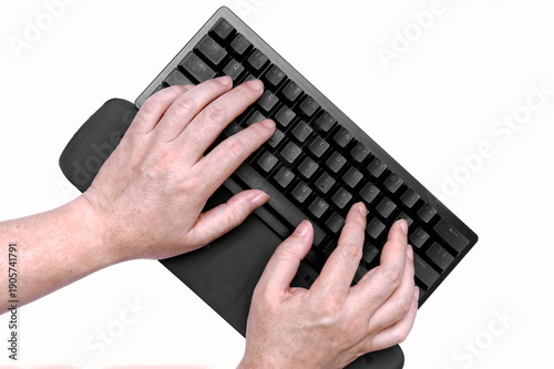 Top view of hands typing on black mechanical keyboard with ergonomic wrist rest.