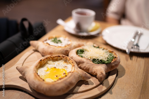 Traditional Georgian breakfast table with three mini khachapuri varieties, cheese-egg filled, spinach khachapuri, and chicken khachapuri. Khachapuri, one of Georgia’s most iconic dishes.