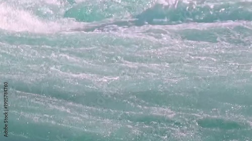 Experience the sheer power of nature as the Saint Lawrence River surges forward. Witness its turbulent flow and exquisite aqua hue on a bright afternoon.