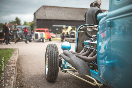 Schilderij op canvas Classic blue hot rod with exposed engine and chrome details at a car show