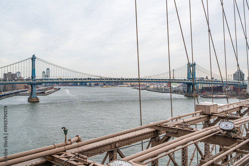 Obraz premium The scenic views of the Brooklyn Bridge, which is a cable-stayed suspension bridge in New York City, spanning the East River between the boroughs of Manhattan and Brooklyn.