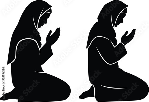 Two women in traditional attire kneeling and praying in silhouette