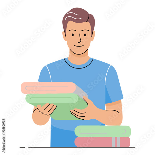 Young man folding colorful bath towels with a smile indoors  