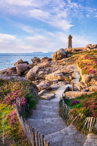 Phare de Mean Ruz on the Pink Granite Coast with rocky shoreline and coastal path in Ploumanach, Brittany, France