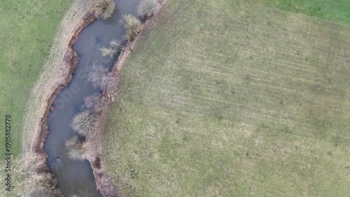 Aerial Drone Flight Along a Winding River Through Rural Farmland
