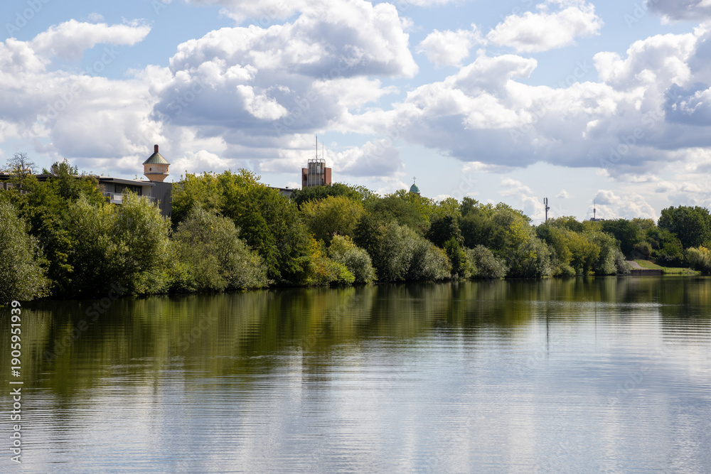 Obraz premium Boat tour on the river near Erba Island (Erbainsel) in Bamberg, Bavaria, Germany, scenic waterway surrounded by nature, green riverside landscape and relaxing European travel destination.