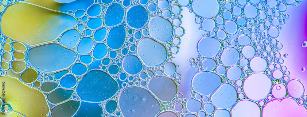 Εκτύπωση καμβά Macro of oil water bubbles in dominant blue tones with yellow and purple accents, glossy iridescent surface, clustered organic pattern with refractive highlights, smooth texture